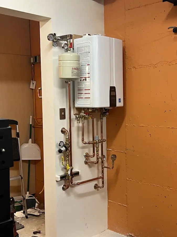 Plumbing technician inspecting water heater connections in Prior Lake